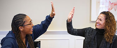 A student and teacher high fiving