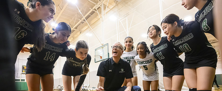 Volleyball team huddled with their coach Volleyball team huddled with their coach
